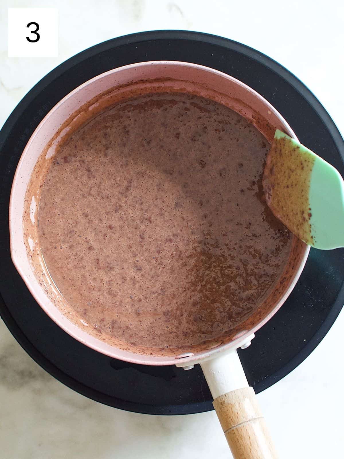 a mixture of butter, sweetened condensed milk, and cocoa powder in a saucepan.