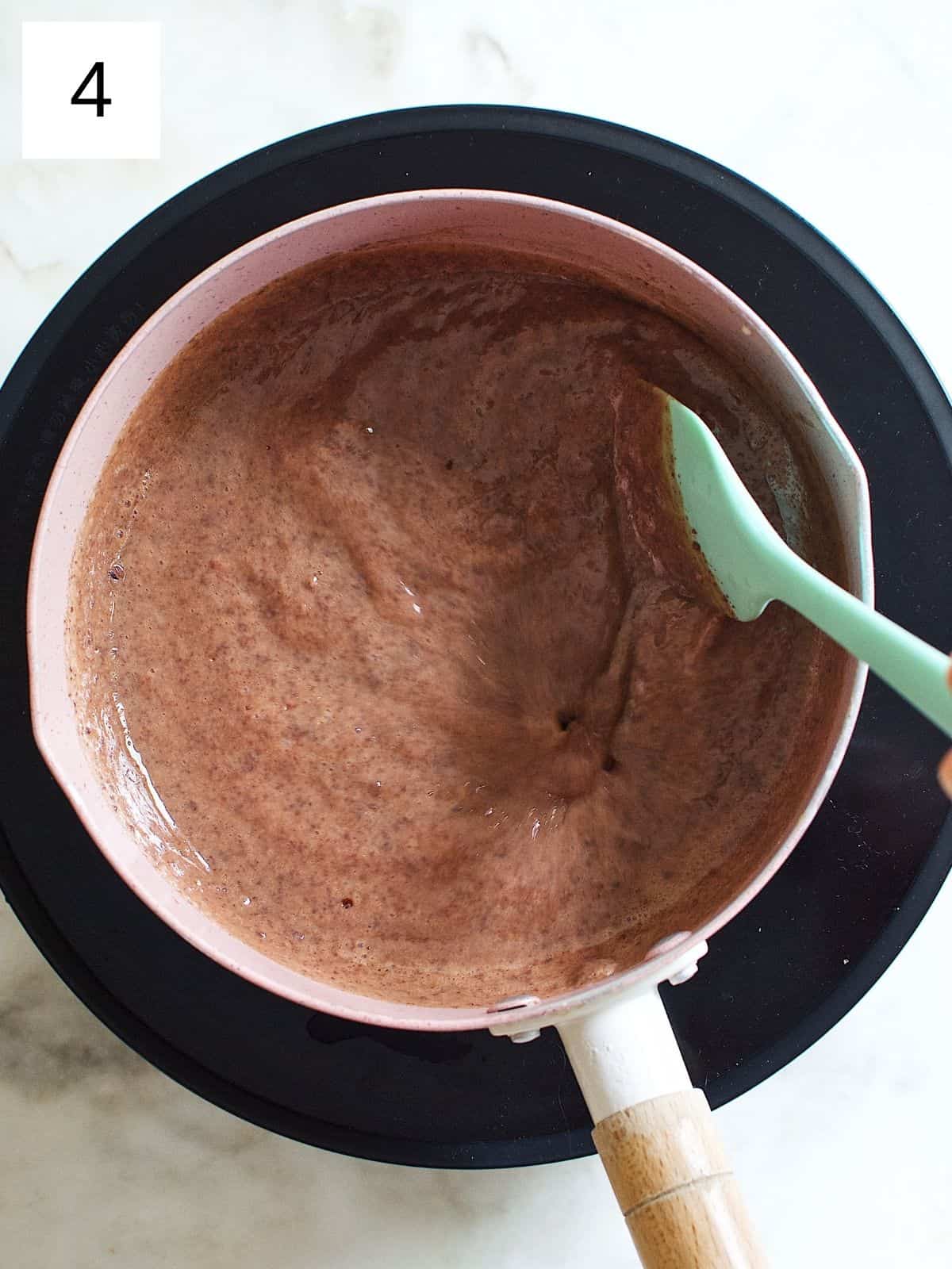 thickened mixture of butter, sweetened condensed milk, and cocoa powder in a saucepan.