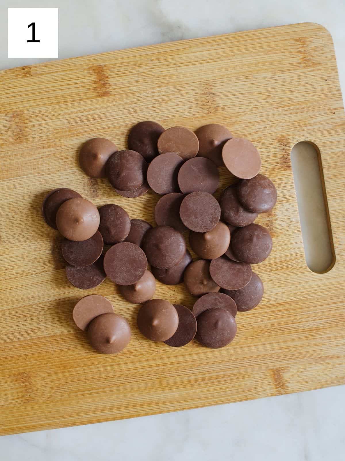 chocolates on a wooden cutting board.