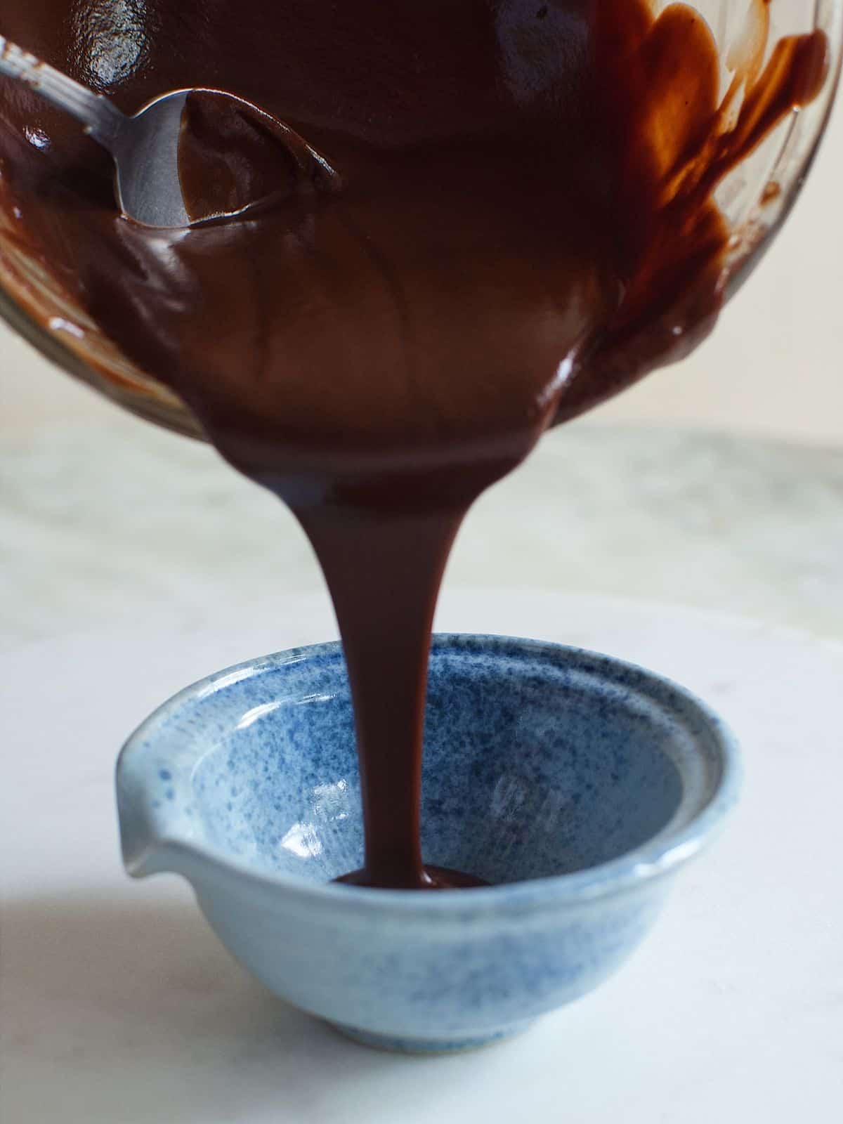 melted chocolate being poured into a bowl.