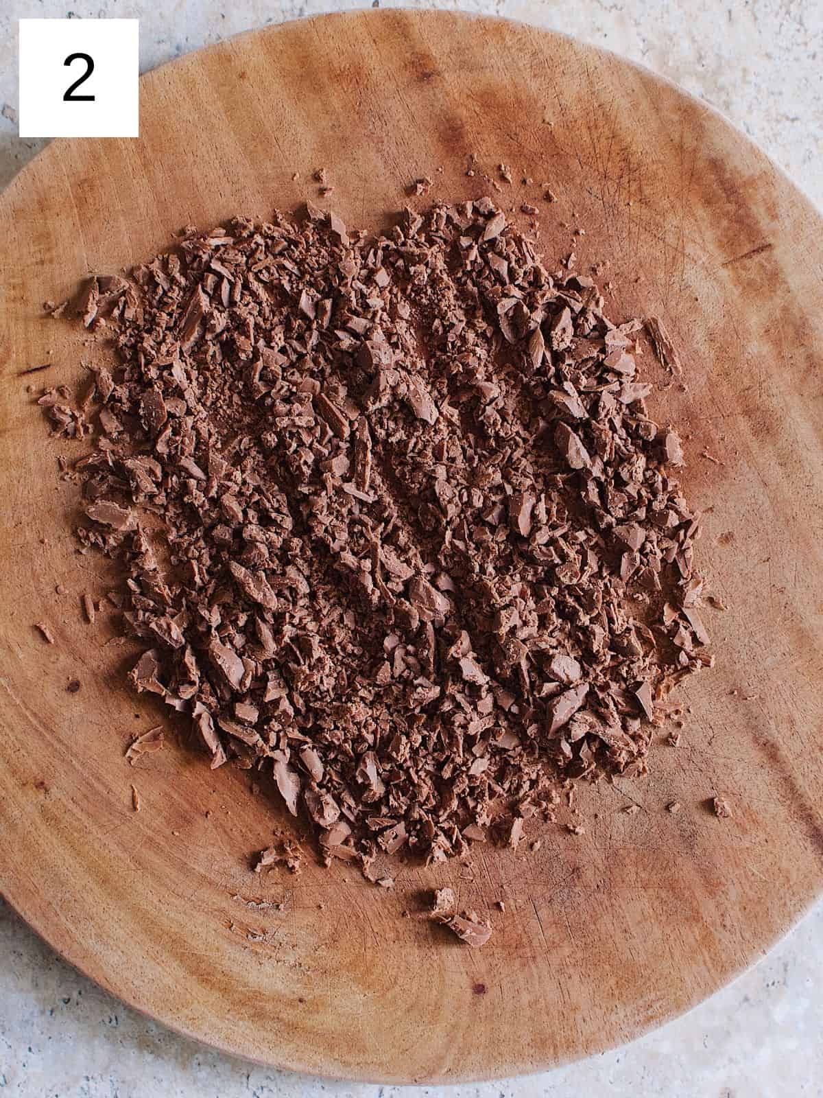 chopped chocolate on a wooden cutting board.