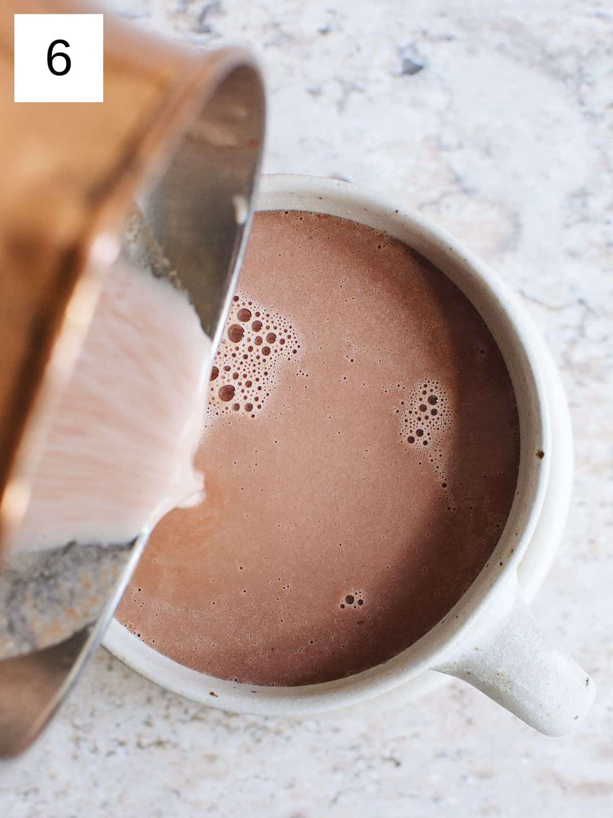 a person pouring hot chocolate into a bowl.