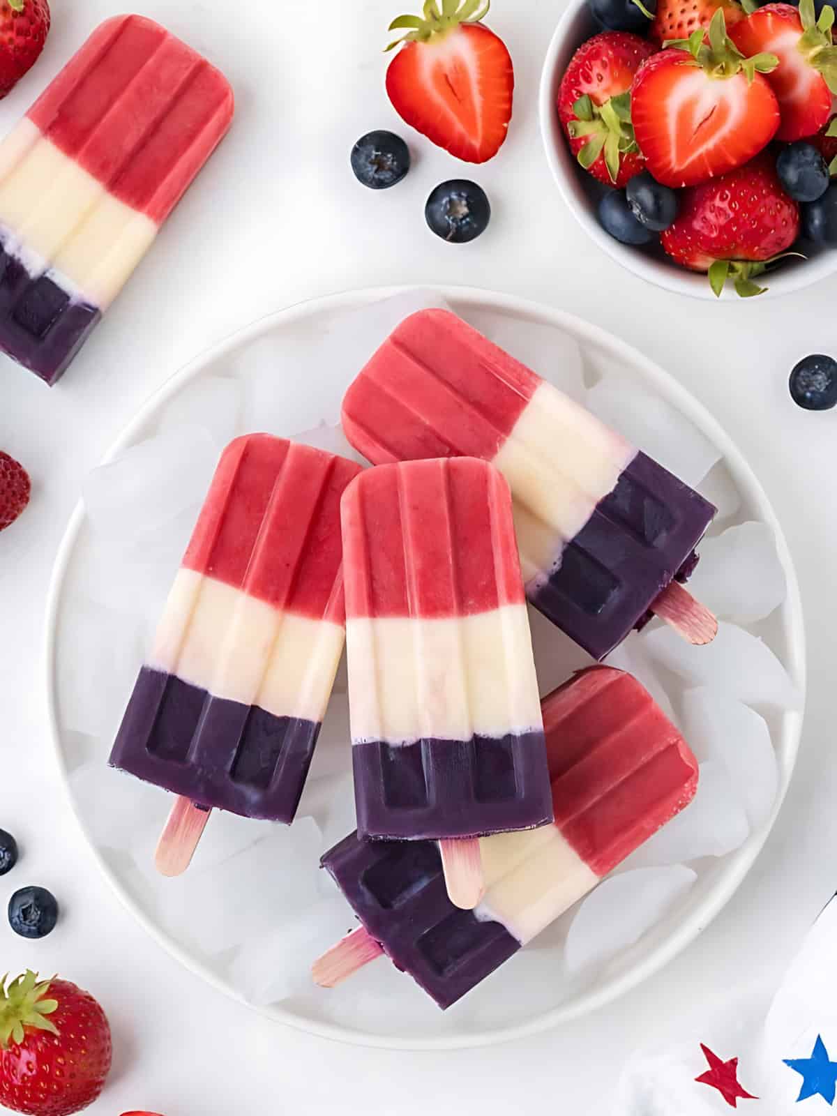 red white and blue popsicles resting on ice cubes.