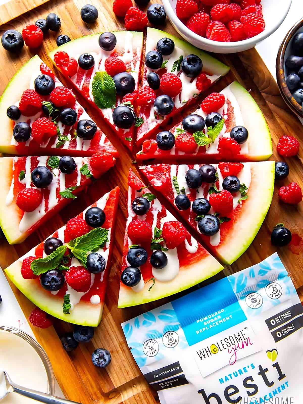 Watermelon pizza topped with blueberries and raspberries.