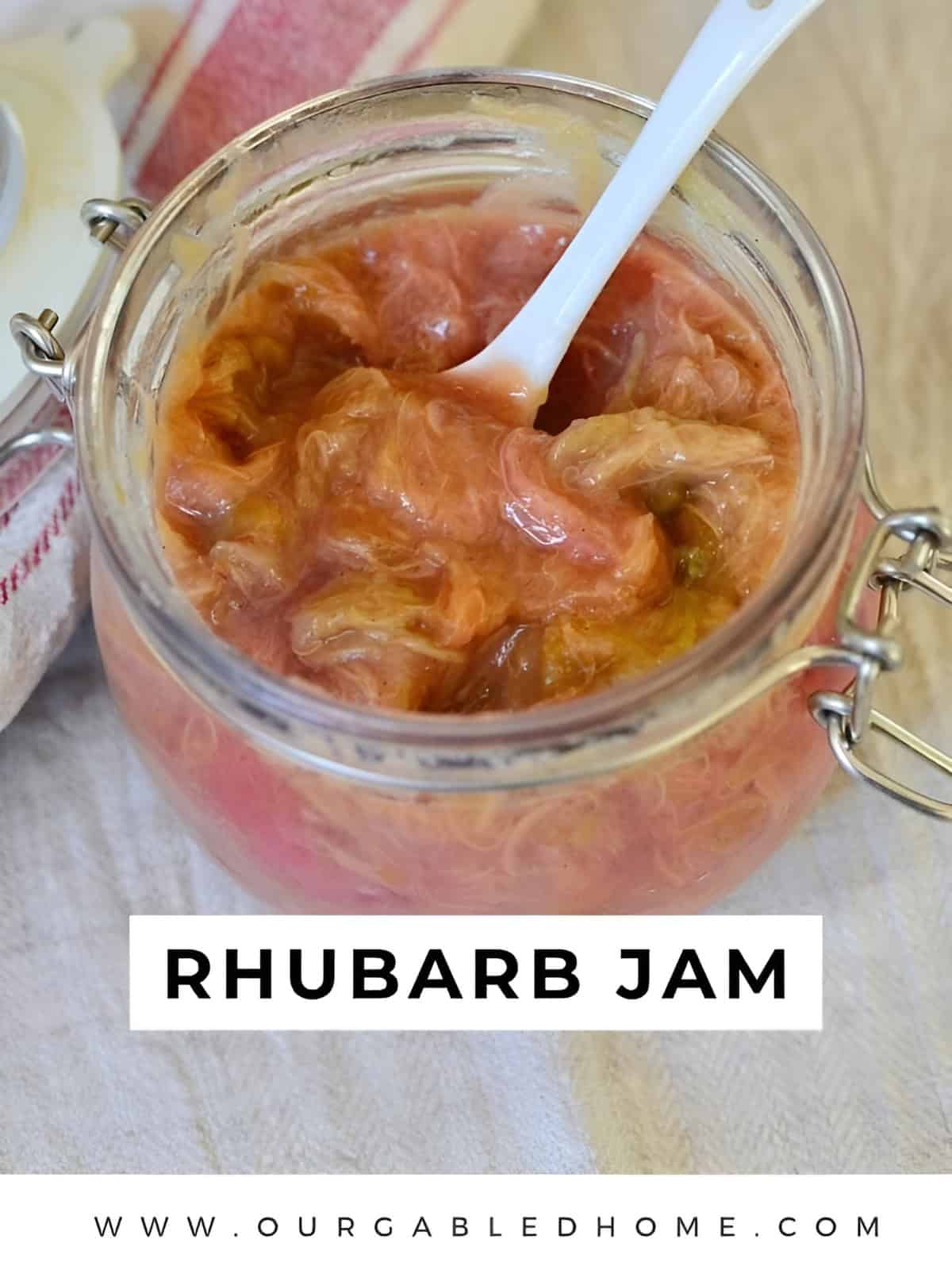 Rhubarb jam in a jar being scooped by a spoon,
