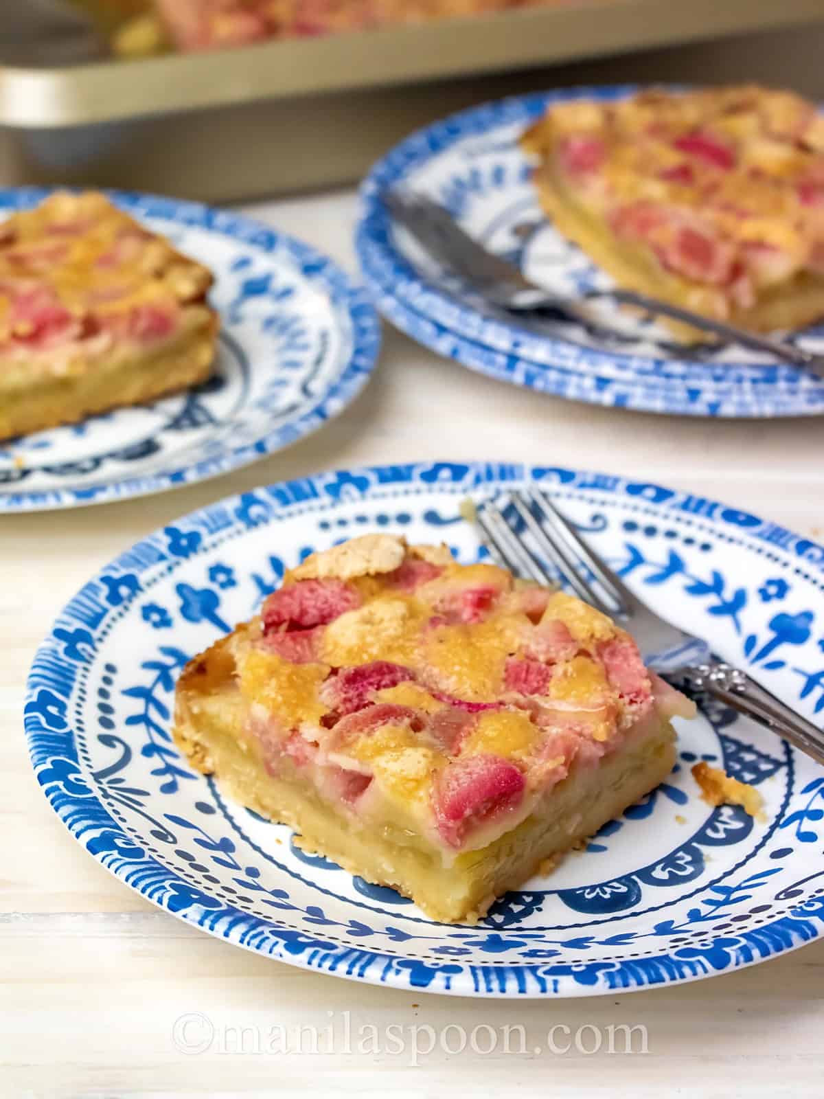 Rhubarb dream bars on a plate next to a fork.