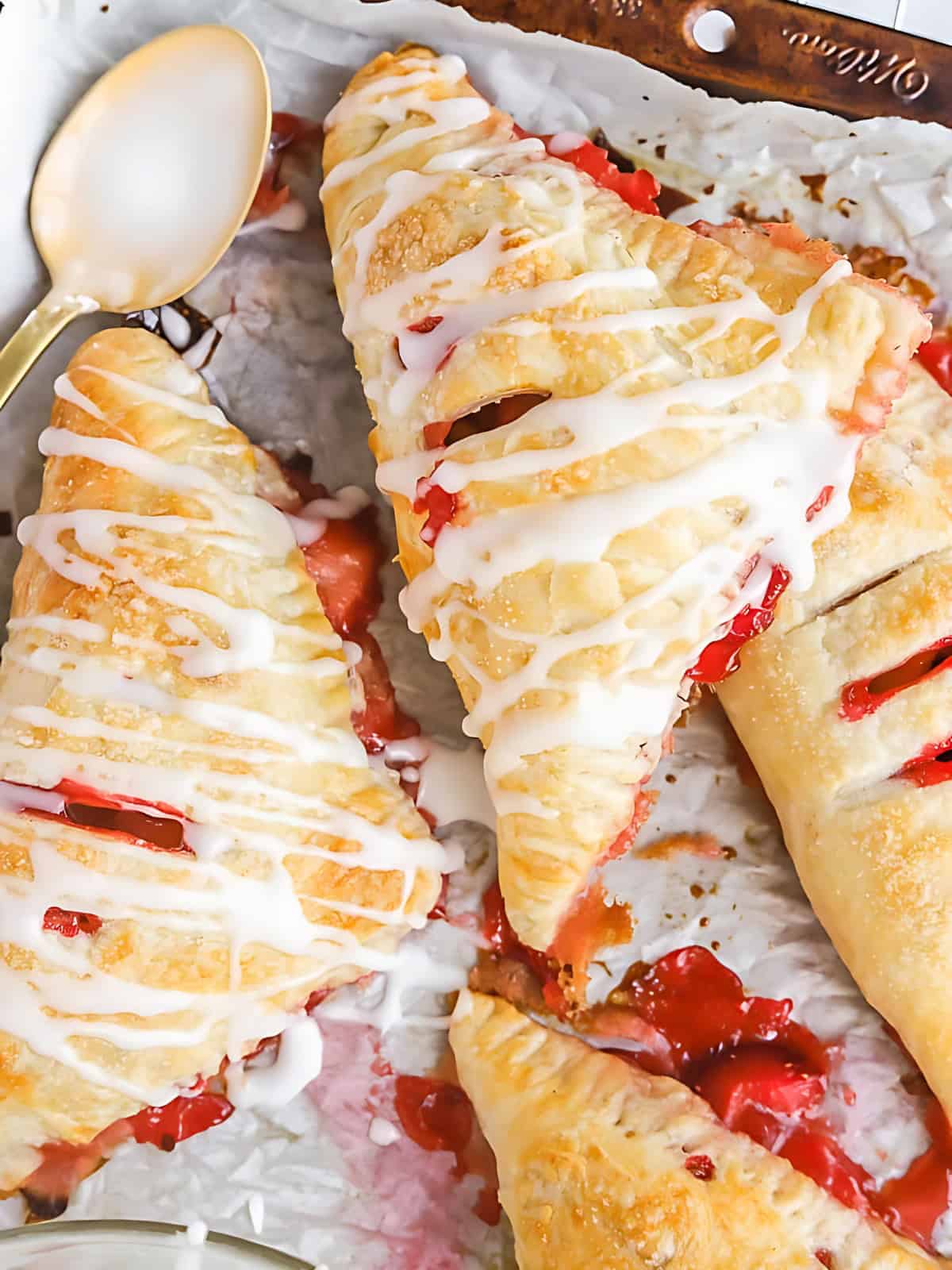Strawberry rhubarb hand pies drizzled with melted sugar cream.