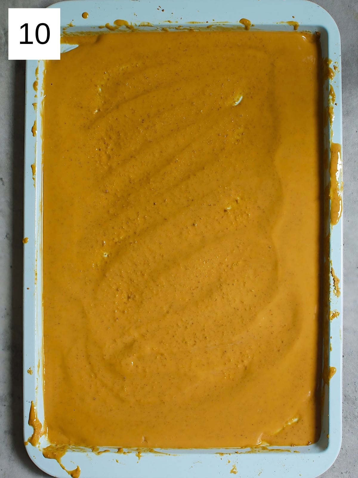 Brown colored melted white chocolate in a baking tray.