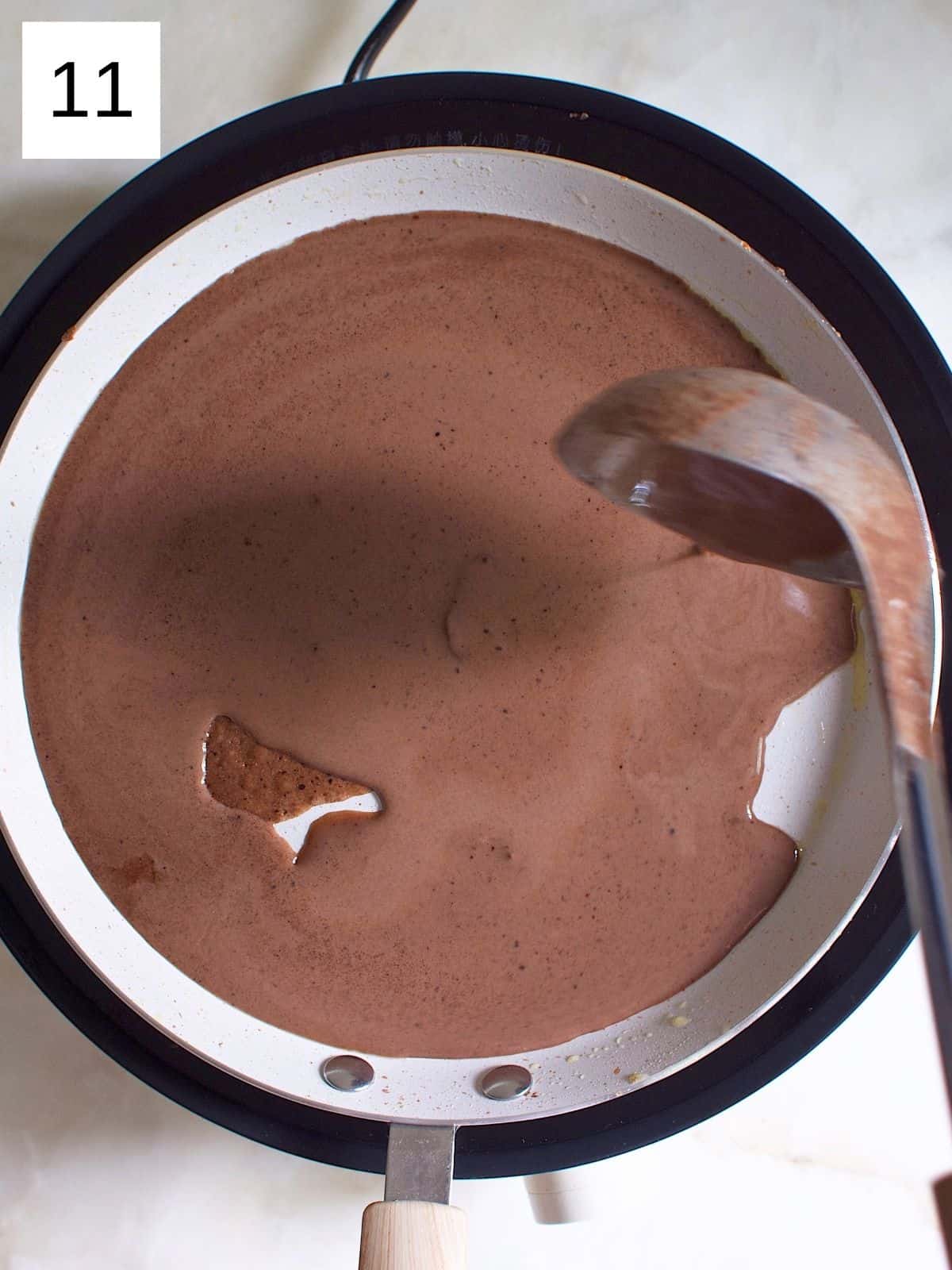 Fully spreading chocolate crepe batter in the pan.