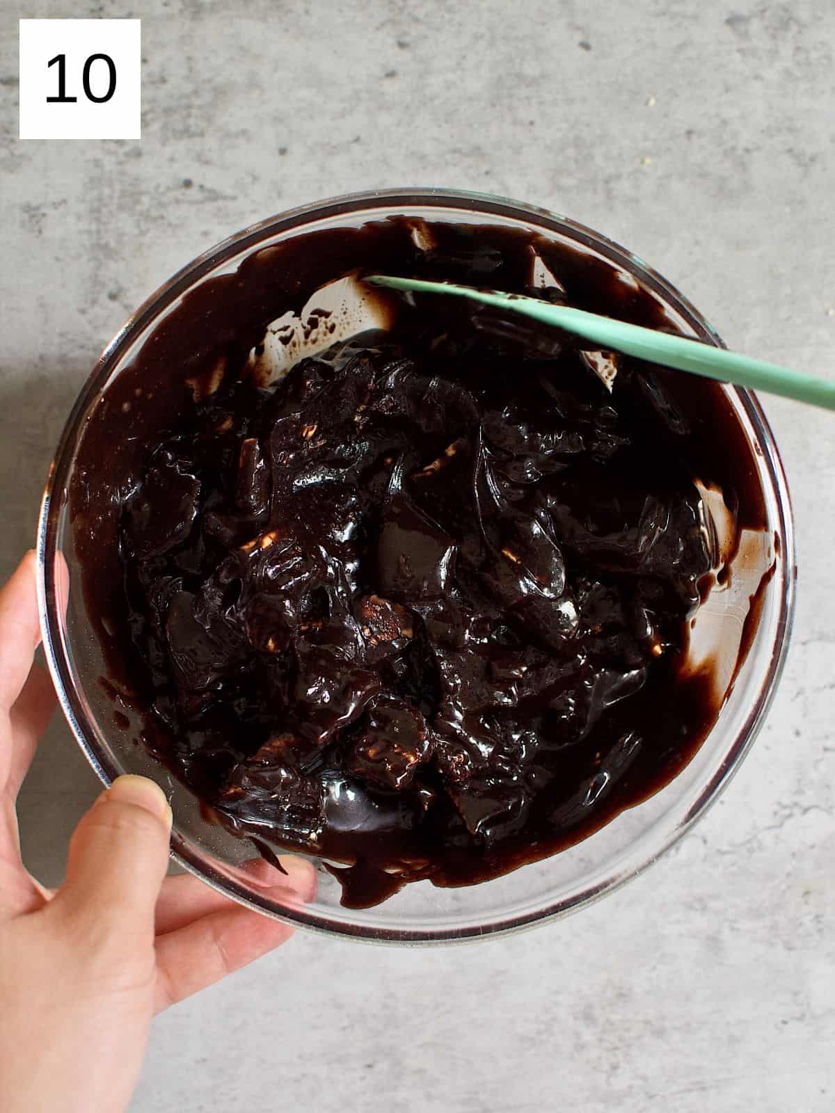 Chocolate mixture and biscuits being mixed in a bowl.