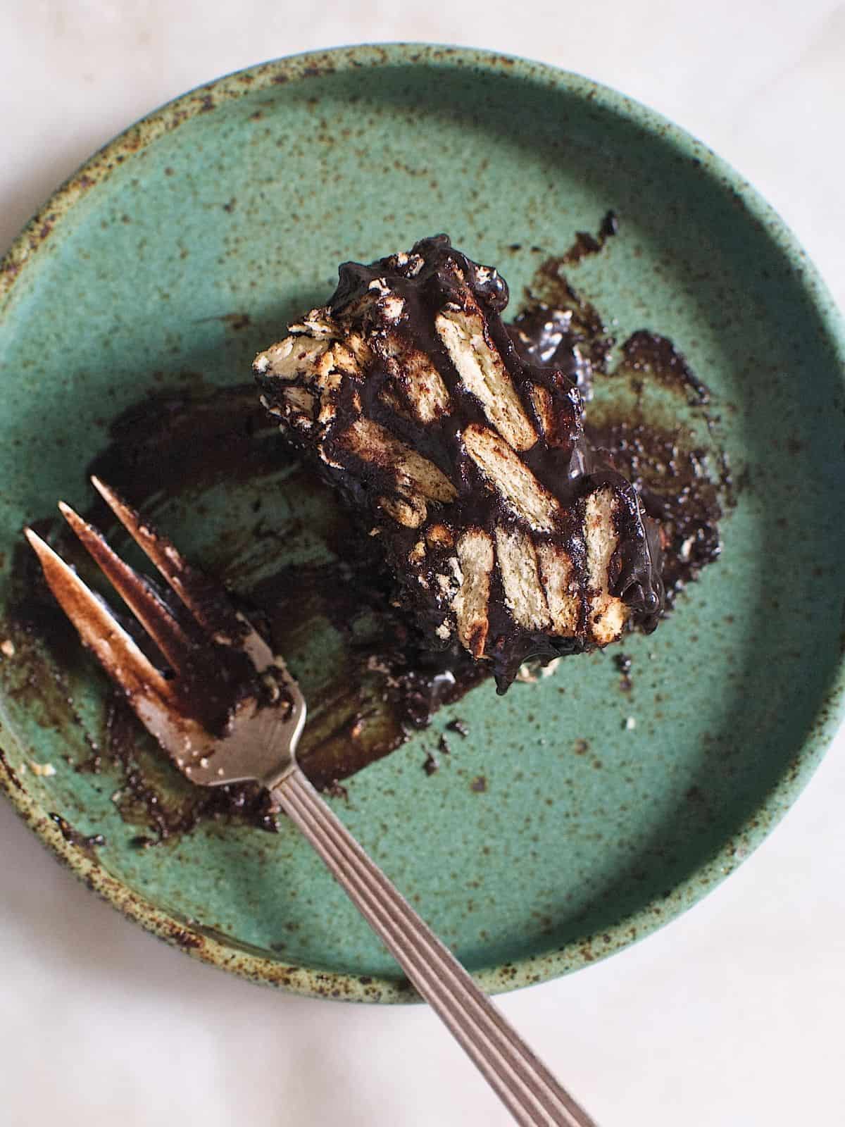 A piece of chocolate lazy cake in a plate next to a fork.