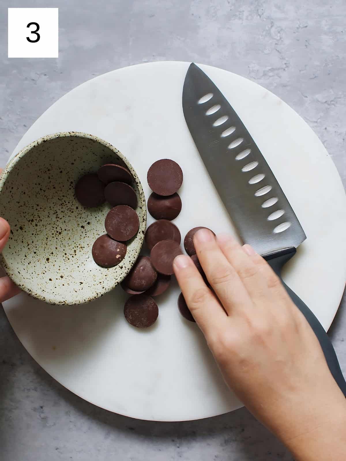 A person transferring chocolate to a plate, next to a knife.