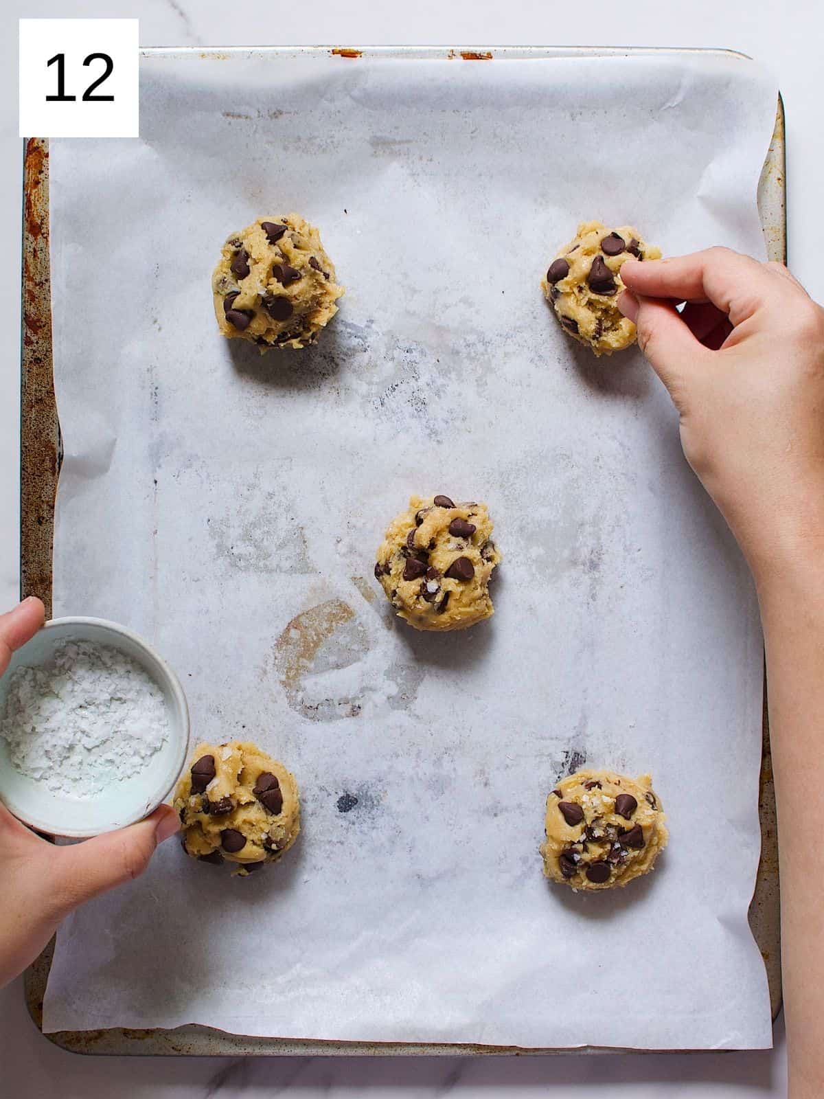 Maple syrup chocolate chip cookie dough in a baking tray sprinkled with baking soda.