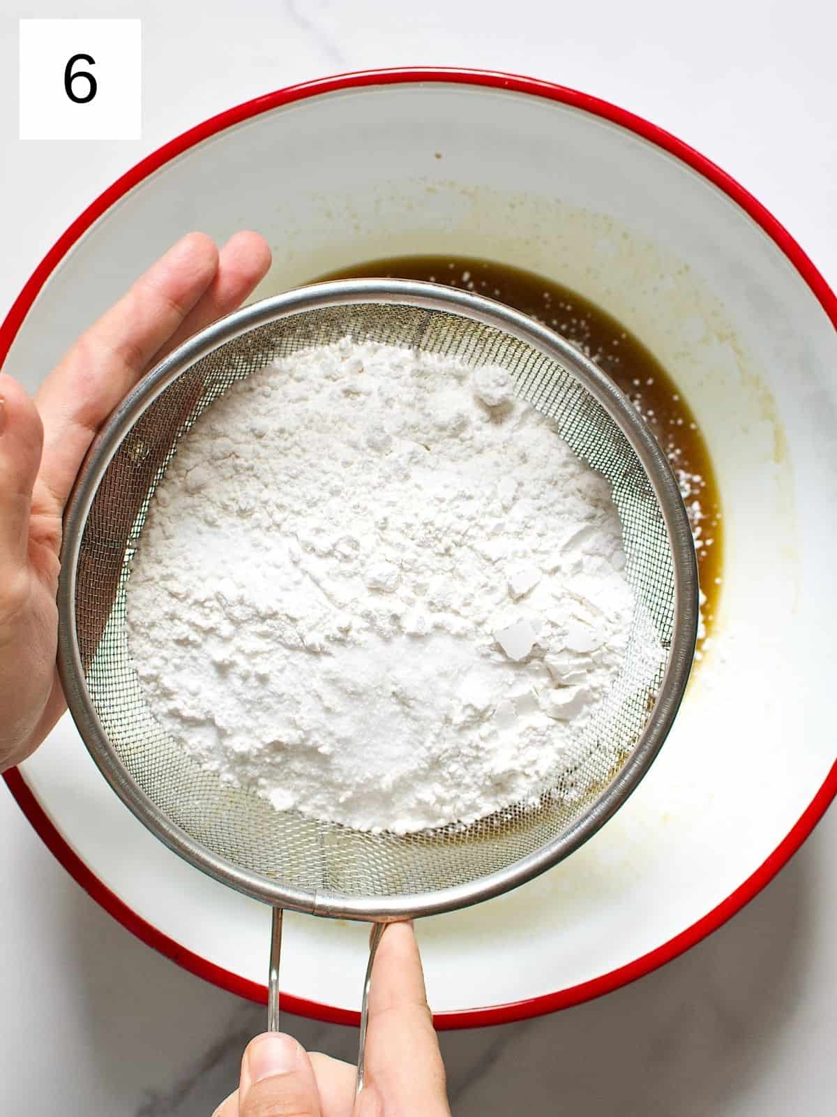 All purpose flour being sprinkled on top of the mixture.