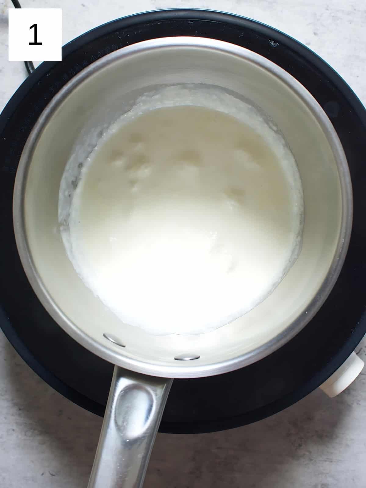 Heavy cream being heated on a pan.