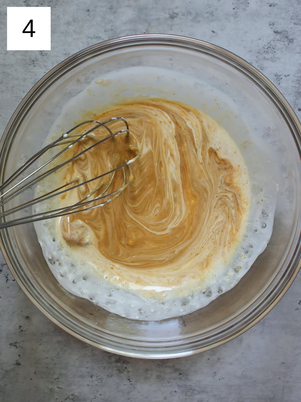 Blonde chocolates and heavy cream mixture being whisked.