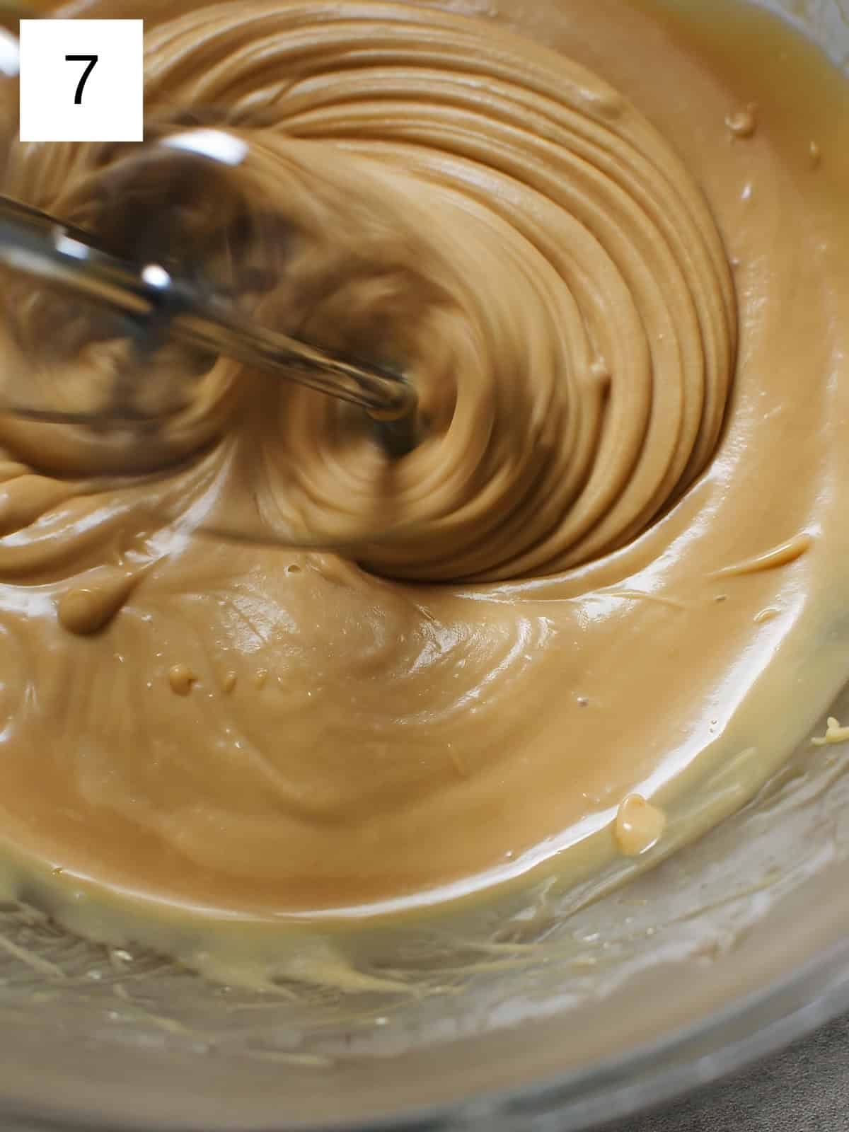 Chocolate ganache being mixed using an electric mixer.