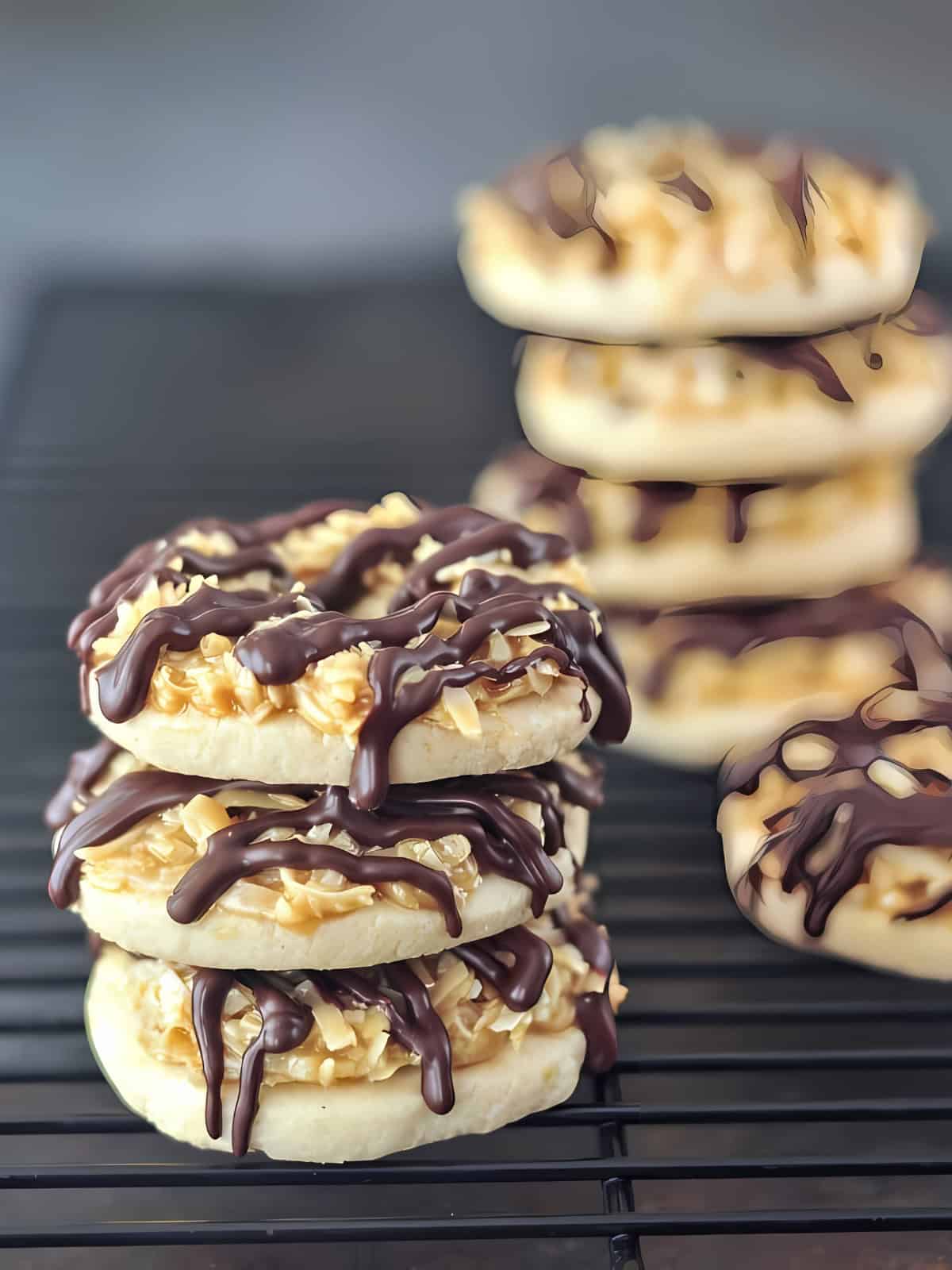 Stacked Samoa cookies drizzled with chocolate.