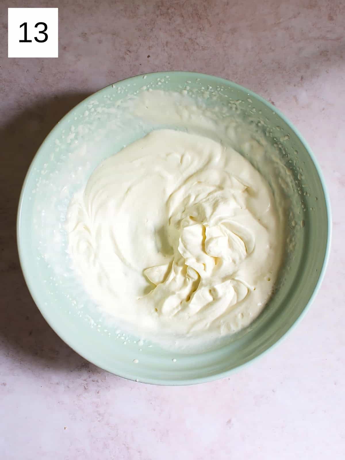 A bowl of whipped heavy cream, powdered sugar, and vanilla extract.