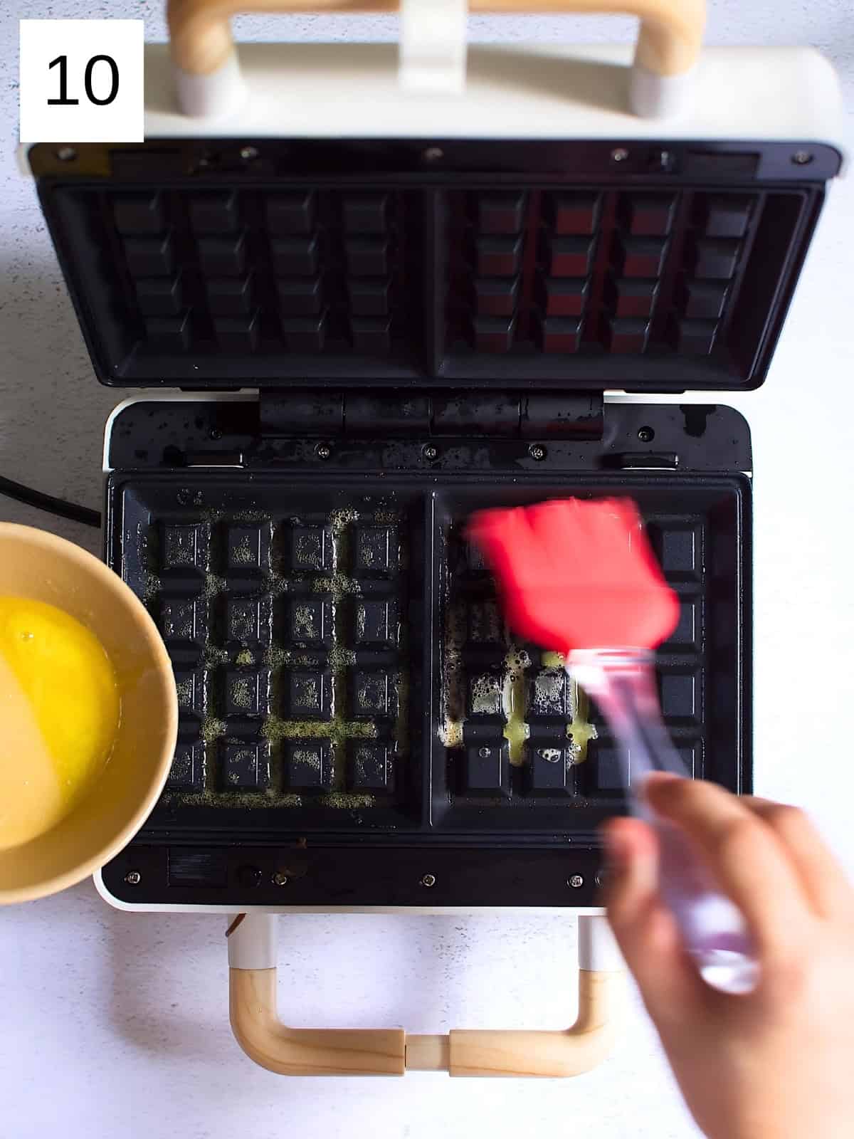 Spreading butter in a waffle maker.