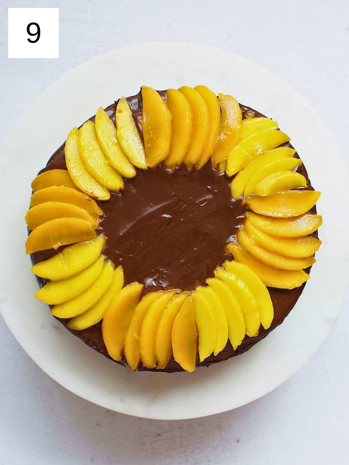 Arranged slices of mangoes on top of a chocolate cake.