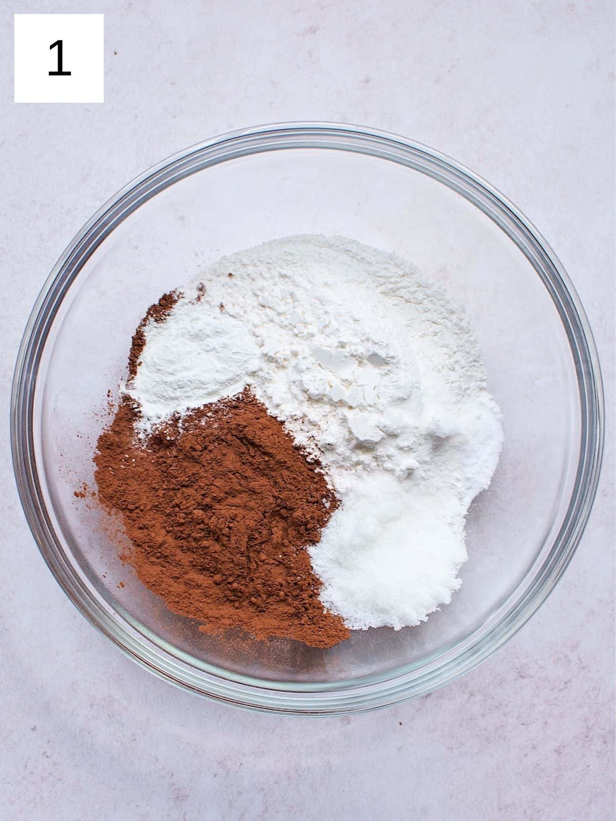 Flour, cocoa powder, sugar, baking powder, salt, and baking soda in a bowl.