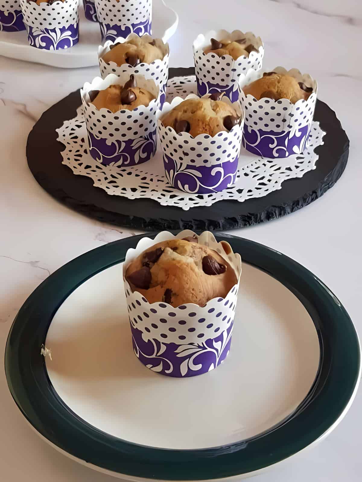 Banana chocolate chip muffins being displayed on a plate.