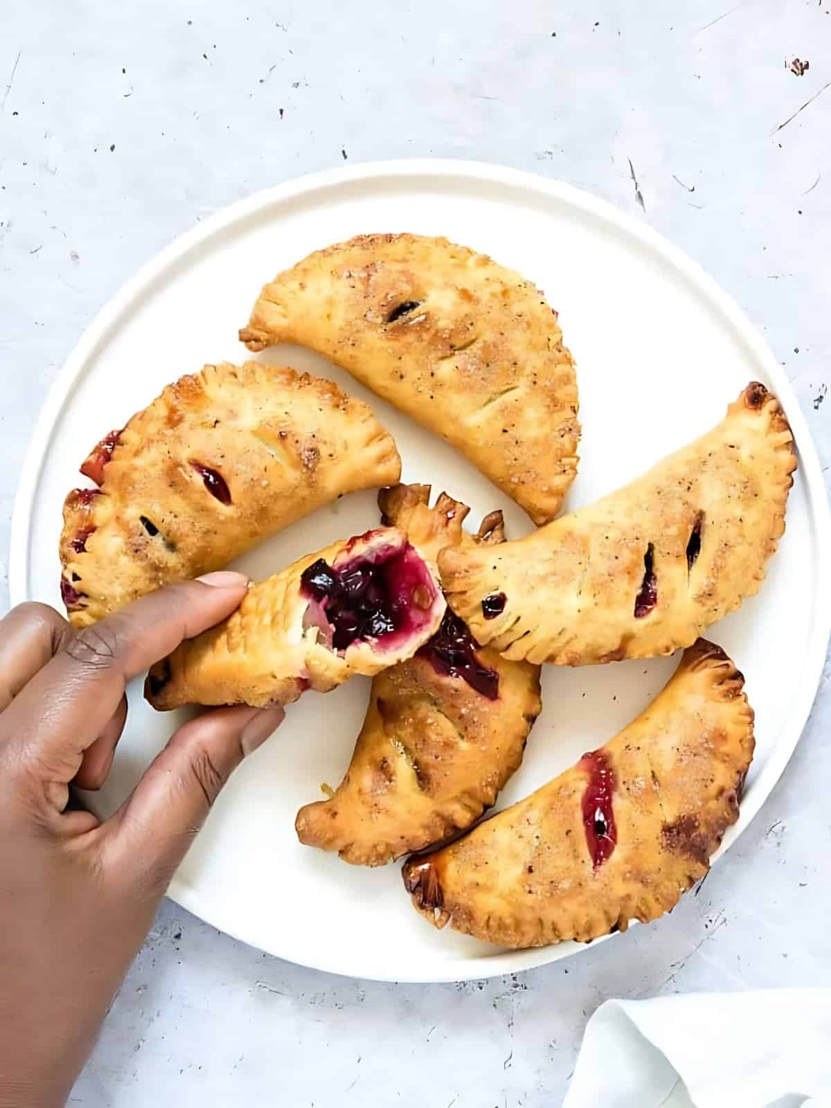 A person holding a blueberry hand pie.