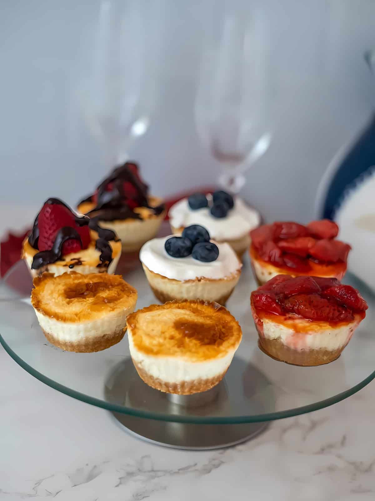 Keto cheesecakes topped with different berries being displayed.