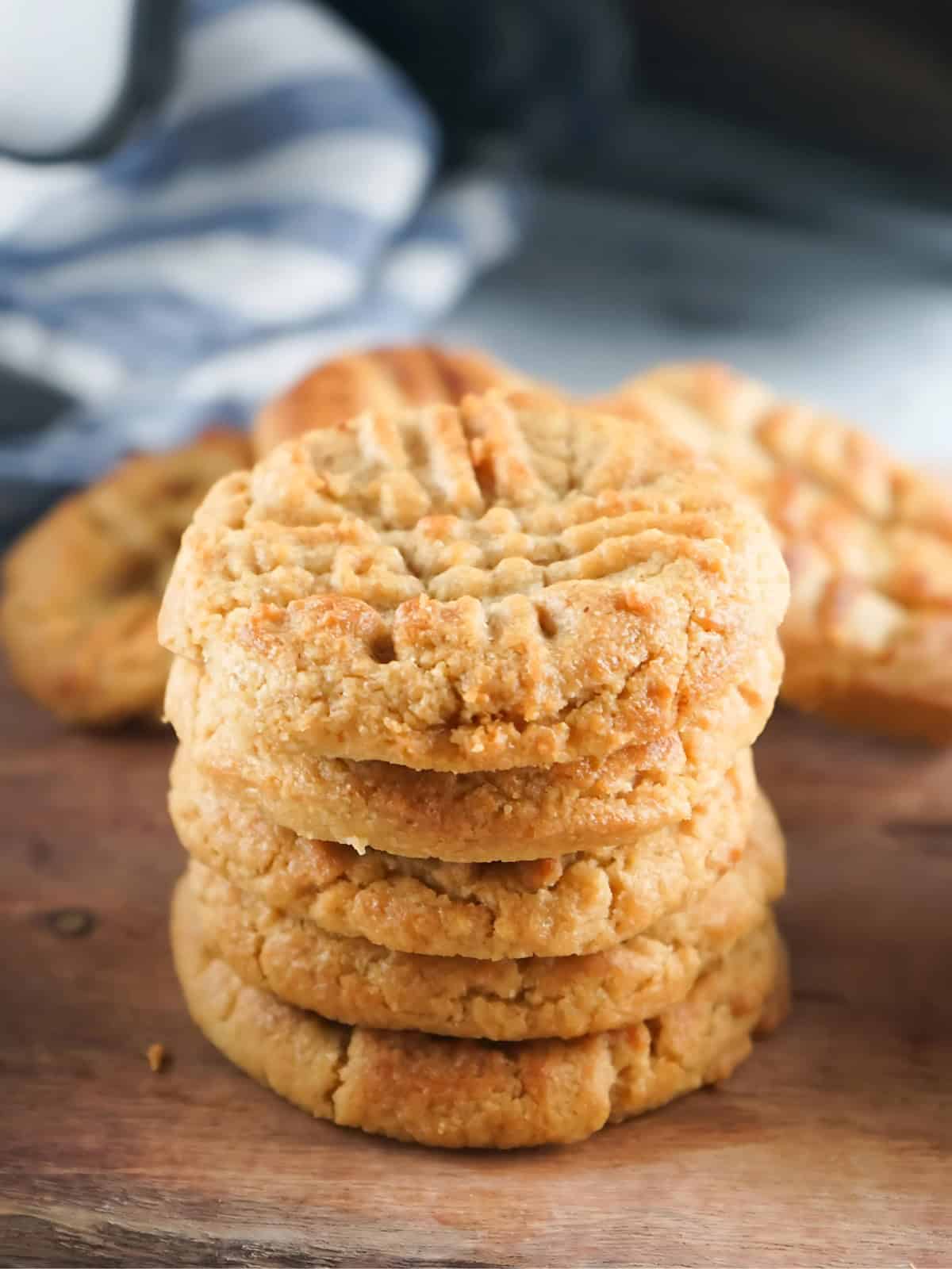 A stack of peanut butter cookies on a wooden board.
