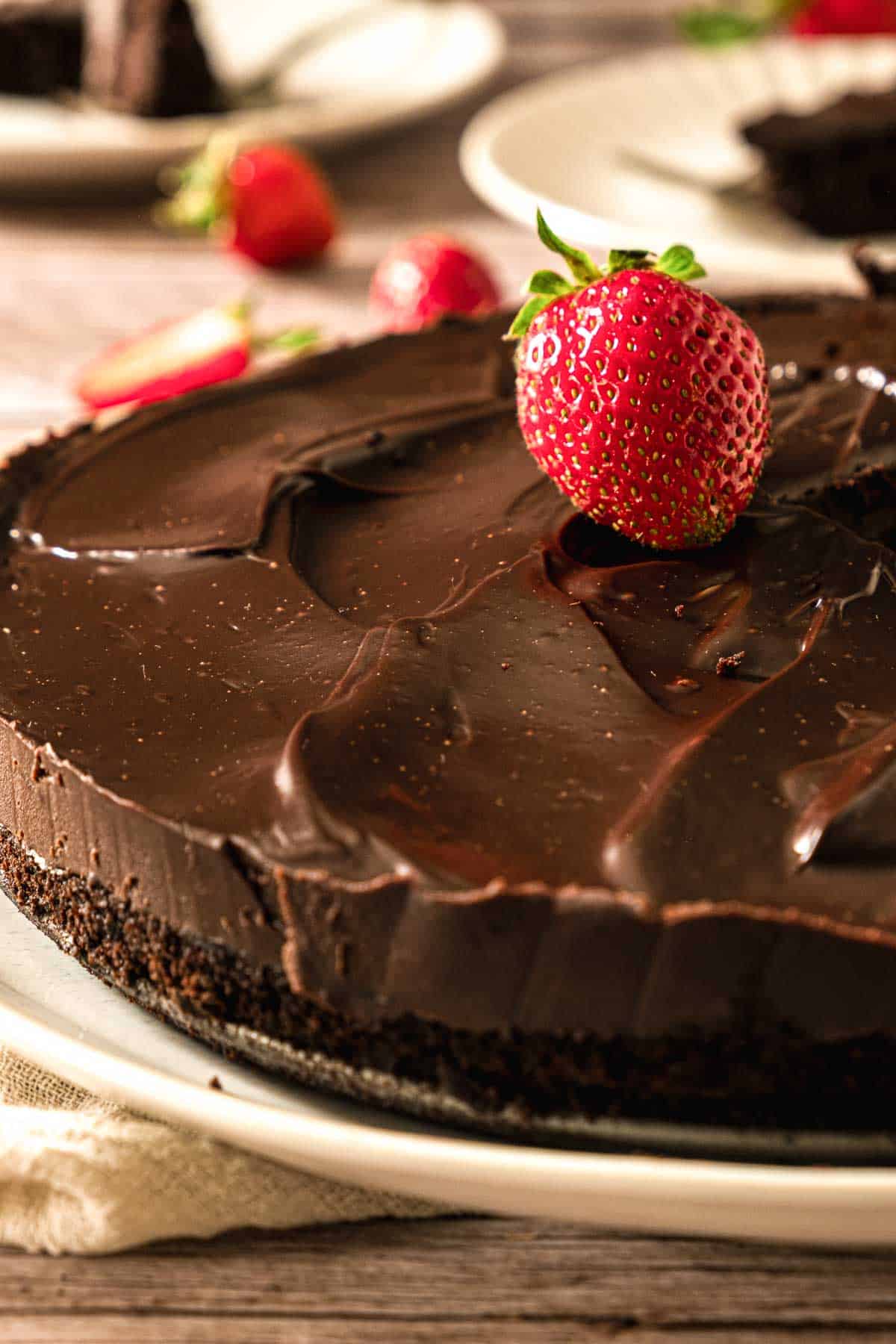 Black bean cake topped with strawberry on a plate.