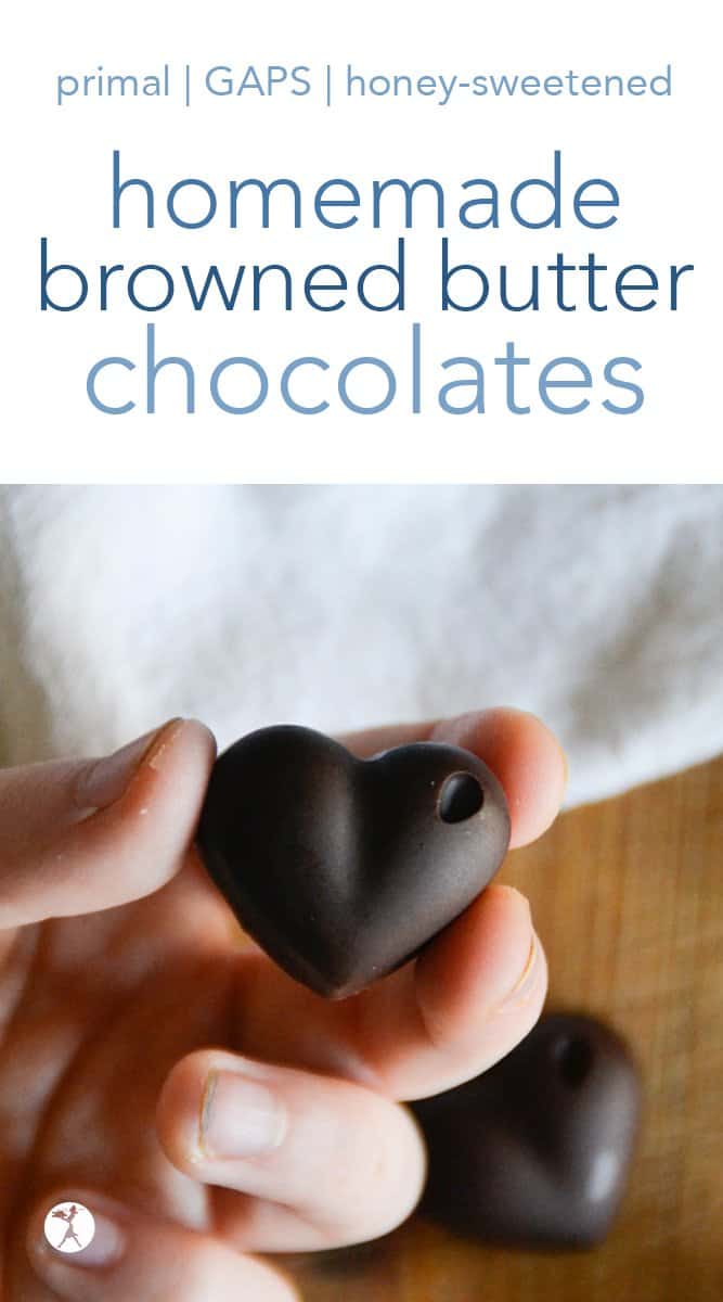 A person holding a heart shaped browned butter chocolates.