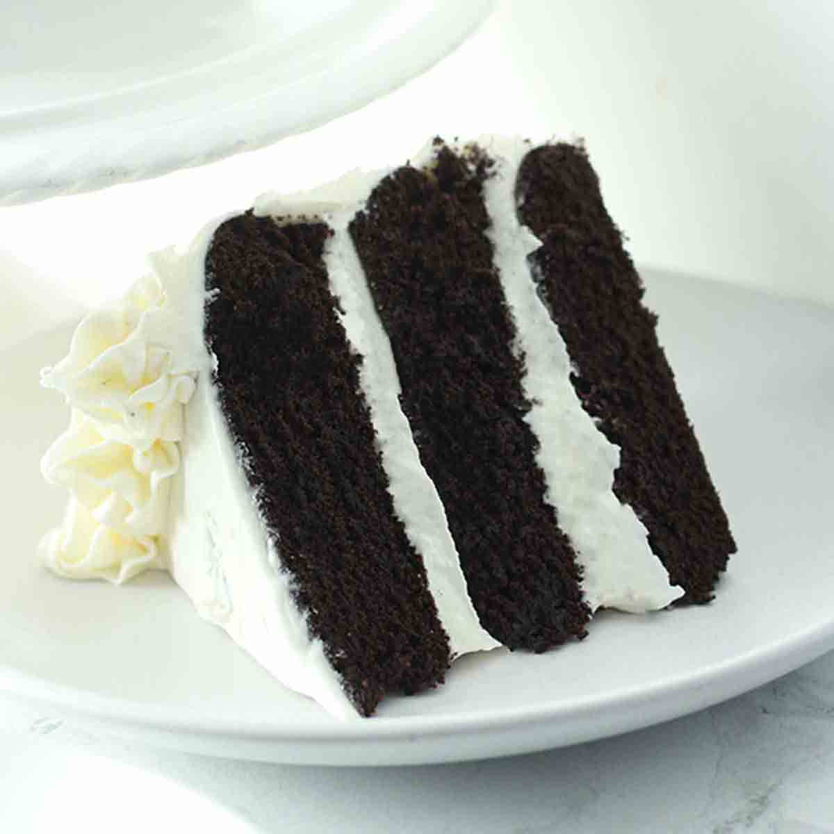 A slice of vegan black velvet cake with frosting.