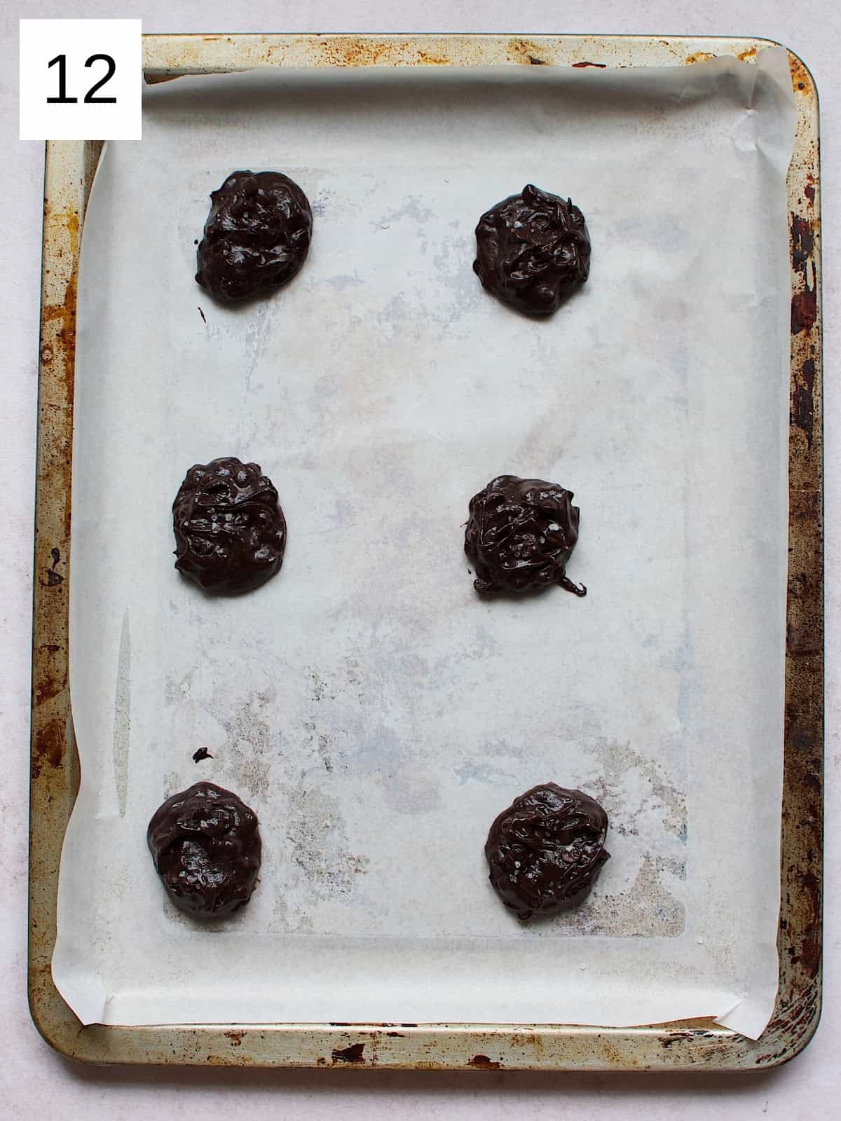 tablespoon-sized mounds of cookie dough onto a baking sheet, spaced about 2 inches apart, ready to be baked.