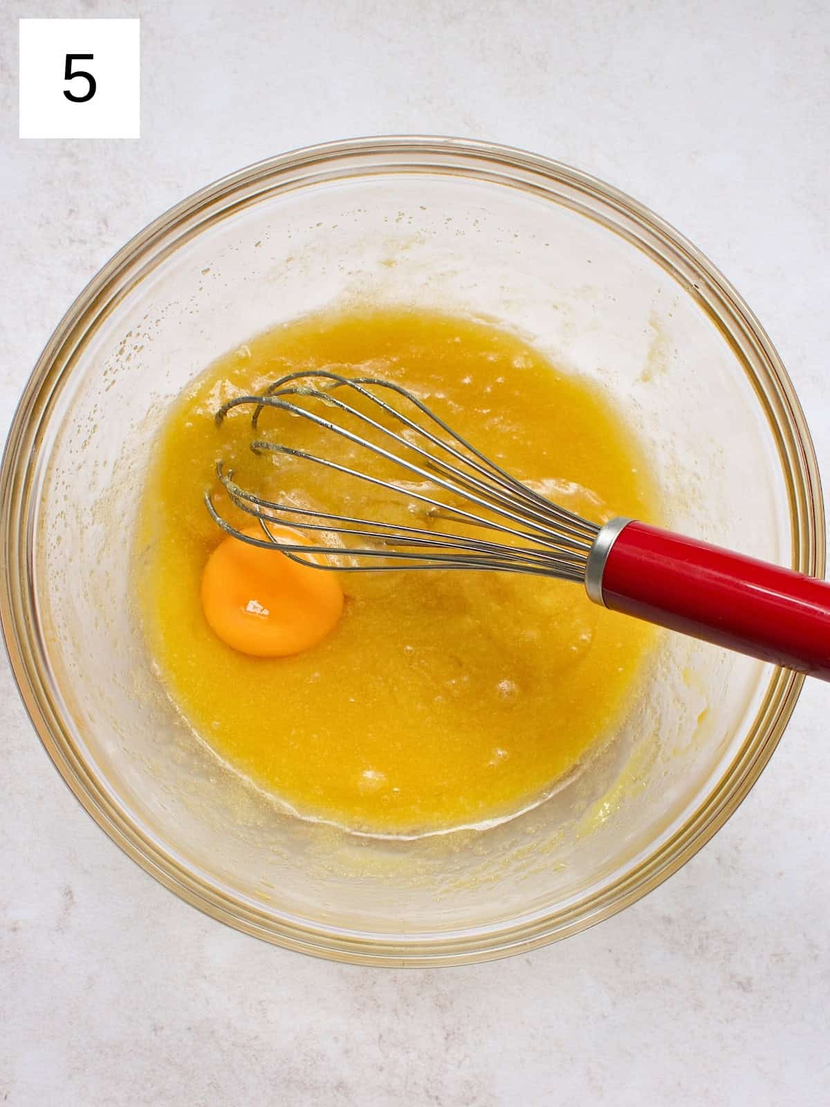 step 5 of making brownie cookies: adding egg and vanilla extract into the butter mixture.