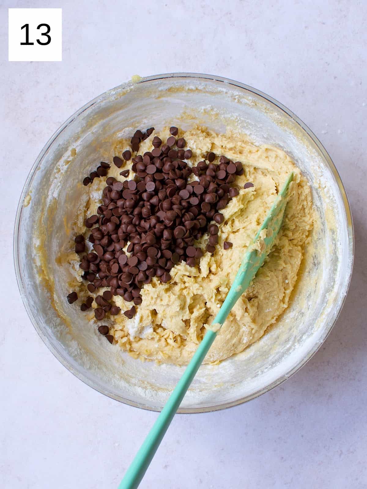 A bowl filled with cookie batter, topped with chocolate chips.