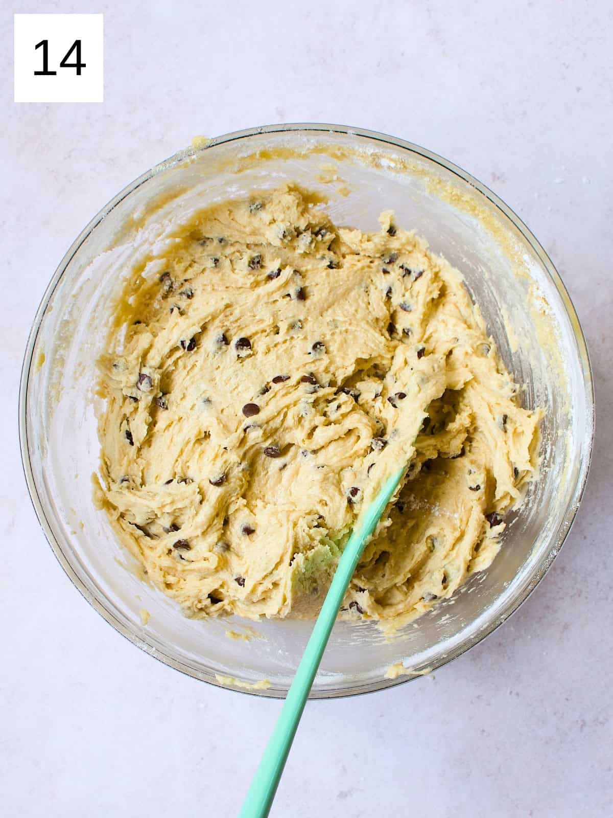 A bowl filled with a cookie batter with chocolate chips.