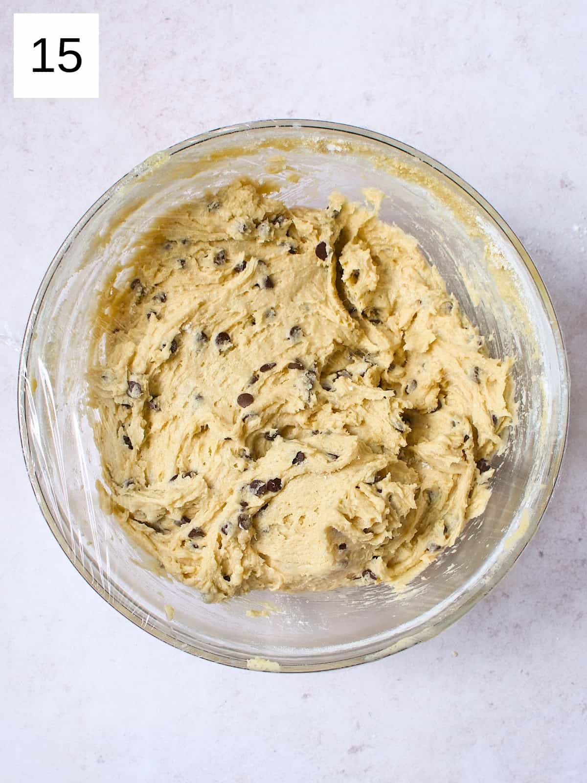 A bowl filled with a cookie batter with chocolate chips.