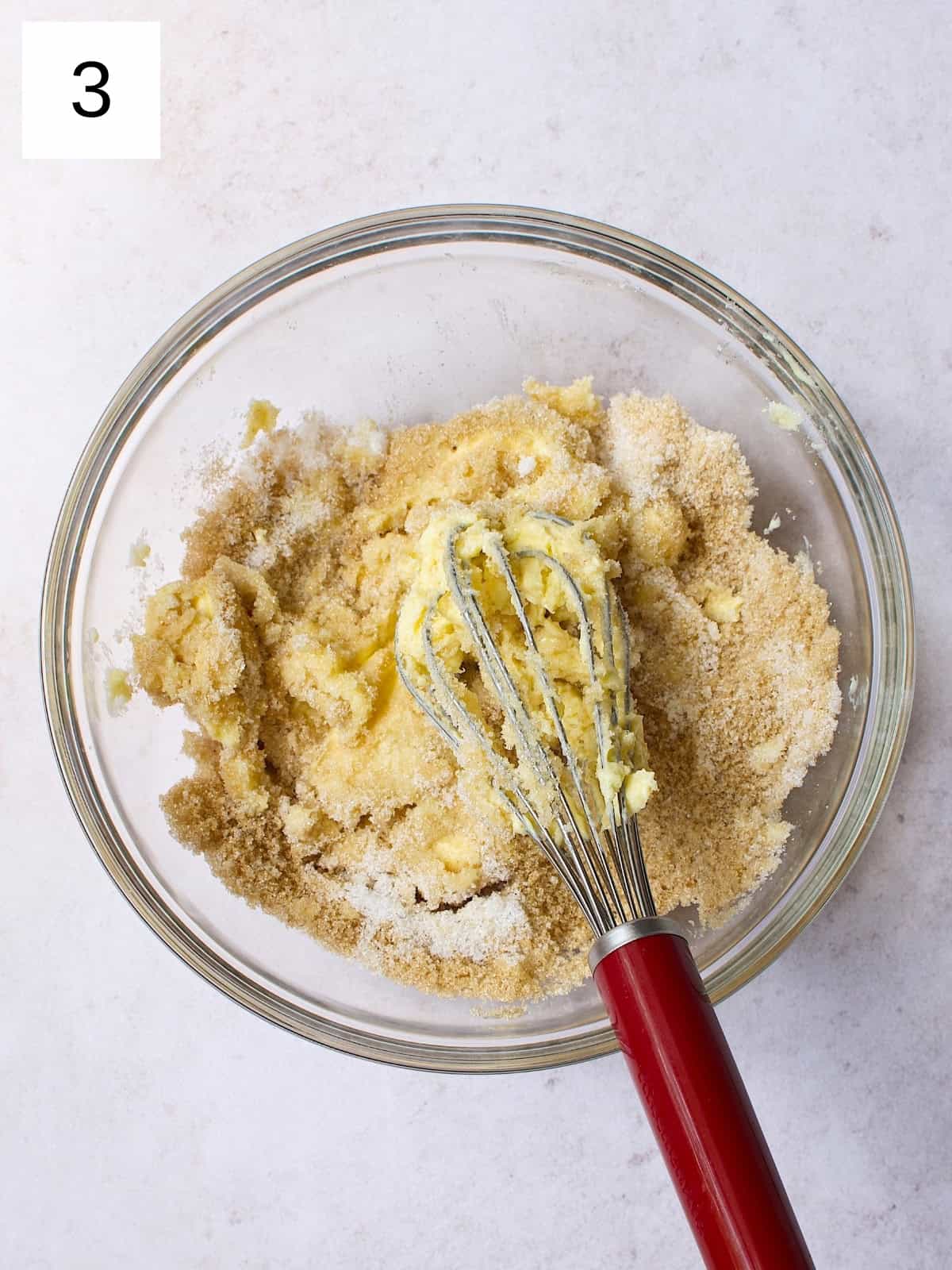 A bowl filled with a mixture of butter, granulated sugar, and brown sugar.