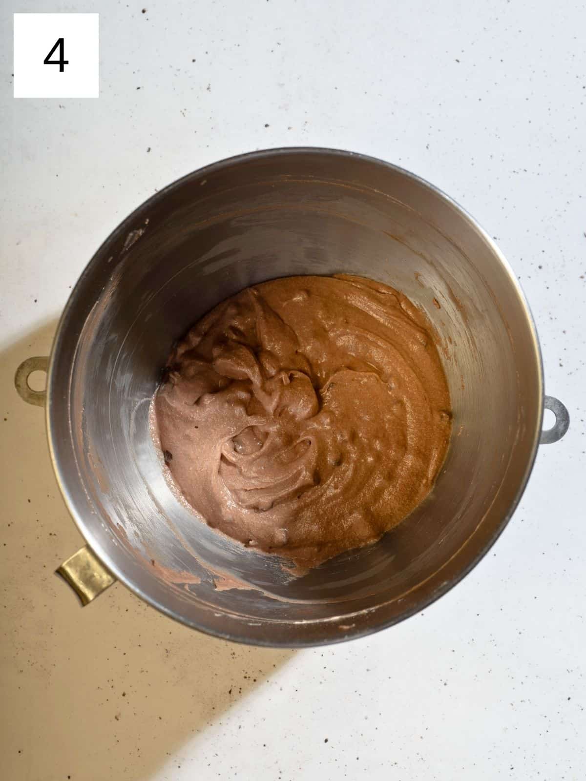 A large mixing bowl filled with whipped brownie batter with chocolate chips, ready to be used in a delicious frosting or dip.