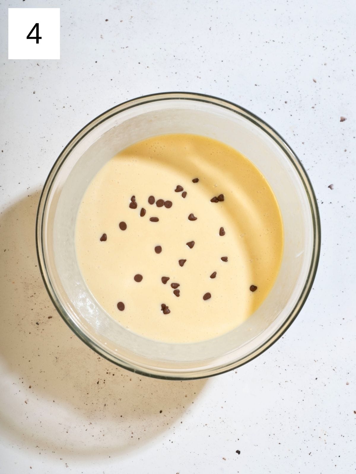 A bowl filled with pancake batter and chocolate chips.