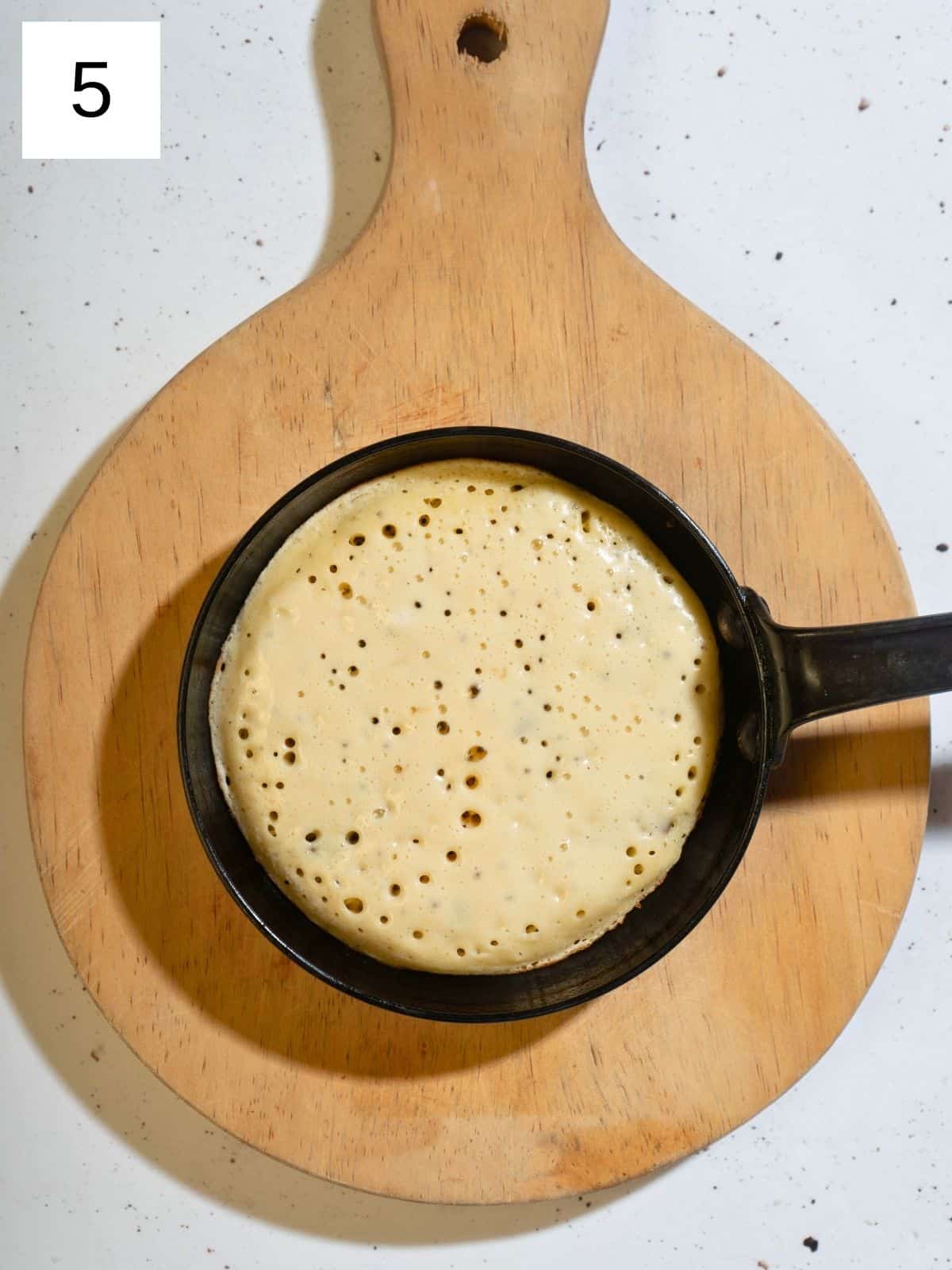 A bubbling layer of pancake batter in a skillet, ready to be flipped for a perfect breakfast pancake.