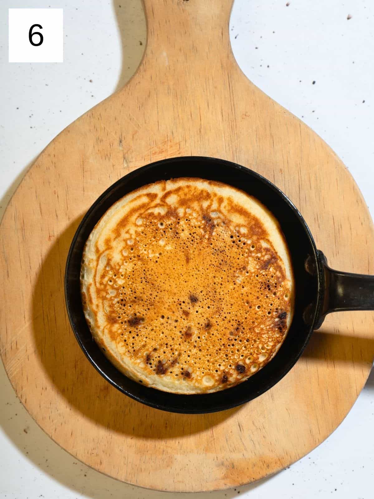 Cooked chocolate chip pancake in a skillet.