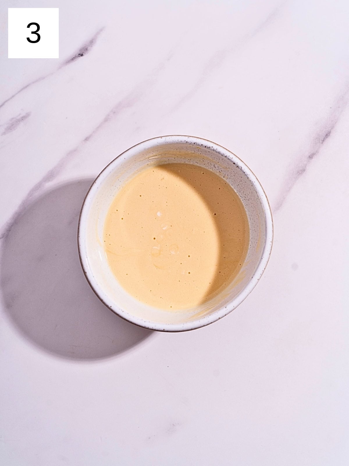 A mixture of vegetable oil. eggs, vanilla extract, and buttermilk in a separate bowl.